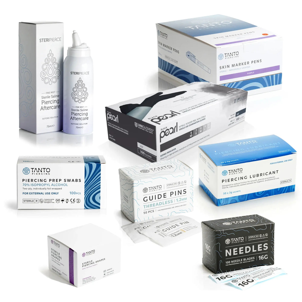 Threadless Piercing Studio Essentials Bundle featuring several piercing products on a white background, with Tanto guide pins, 16G piercing needles, drapes, lubricant, prep swabs, skin markers, Steripierce saline and black nitrile gloves