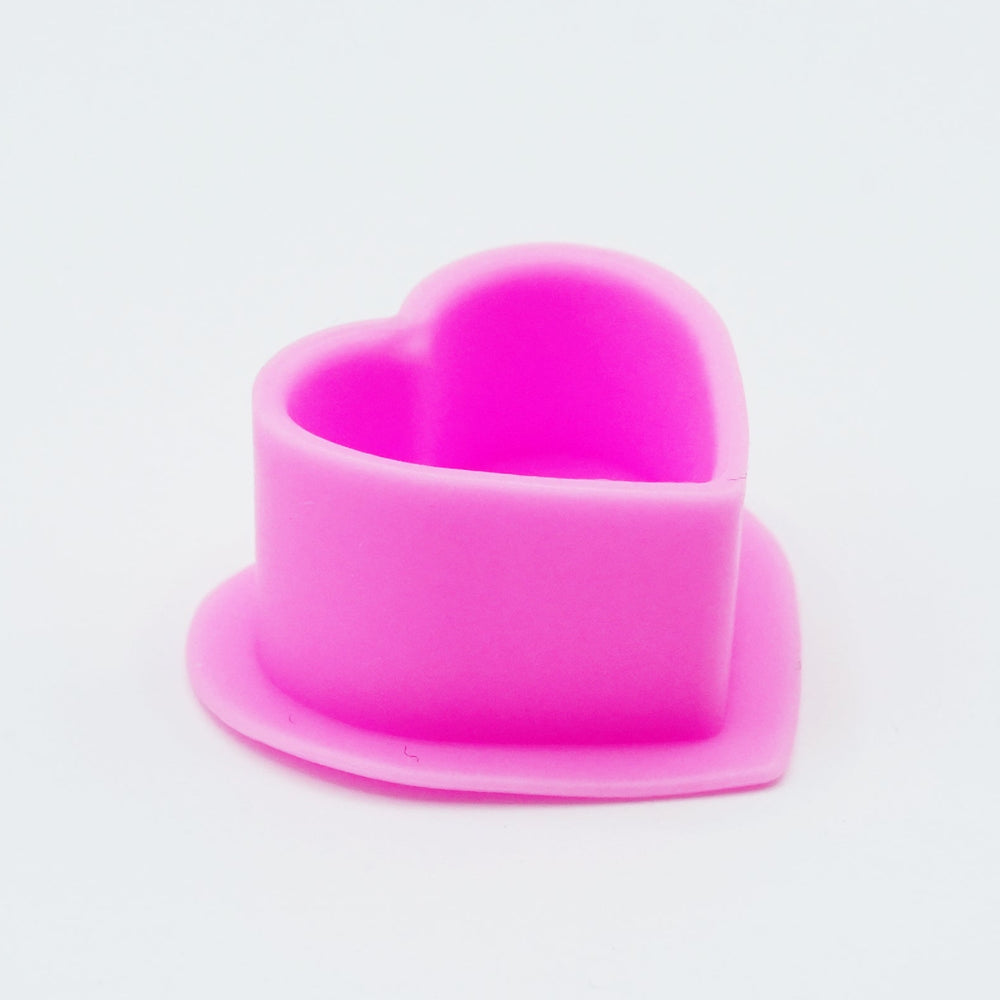 Pink heart-shaped silicone ink capon a white background